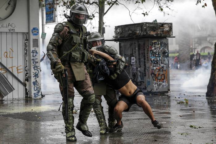 La policía anti disturbios detiene a un manifestante en los enfrentamientos tras una protesta contra el gobierno del presidente chileno Sebastián Piñera en Santiago, el 8 de noviembre de 2019. · Foto: Javier Torres, AFP