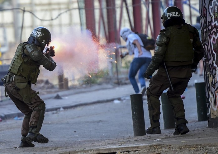 Un policía dispara contra un manifestante durante las protestas contra el gobierno de Sebastián Piñera.  · Foto: Martin Bernetti / AFP