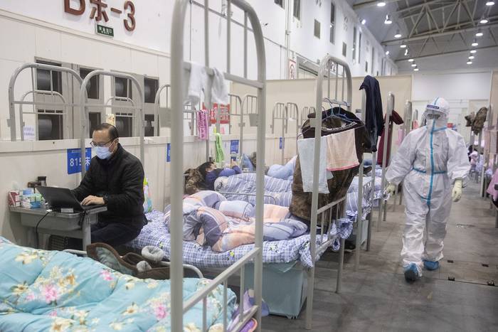 Un hombre con síntomas leves del coronavirus COVID-19 usa una computadora portátil en un centro de exposiciones convertido en un hospital, en Wuhan, en la provincia central china de Hubei. Foto: STR / AFP.