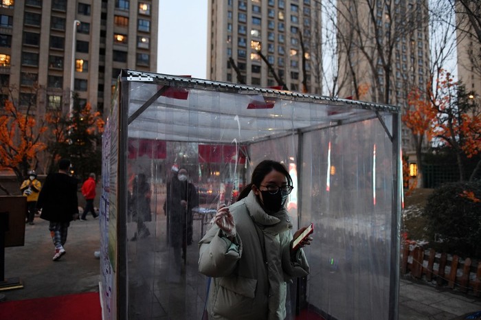 Una residente sale de un canal de desinfección en Tongzhou, Beijing, China. · Foto: Greg Baker, AFP