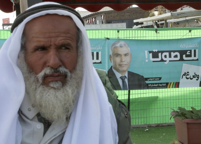Un anciano del Negev observa después de registrarse para votar en la aldea de Shaqib al-Salam, cerca de la ciudad de Beersheva, en el sur de Israel, en vísperas de las elecciones generales. La pancarta de la campaña en el fondo es para el miembro beduino del parlamento (Knesset) Said Al-Khroumi, candidato a la Lista Conjunta Árabe. Foto: Hazem Bader, AFP.