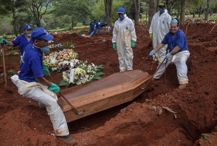 Empleados entierran a una persona que murió presuntamente por COVID-19 en el cementerio de Vila Formosa, en las afueras de Sao Paulo, Brasil, el 31 de marzo de 2020. Foto: Nelson Almeida, AFP.
