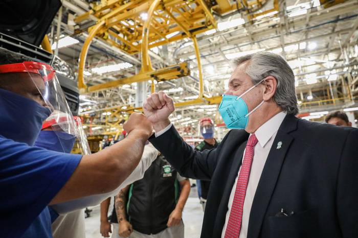 El presidente de Argentina, Alberto Fernández, saluda a un trabajador en la planta de Volskwagen, que retomó su producción.  · Foto: Esteban Collazo, presidencia argentina