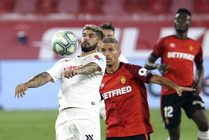 Ever Banega, de Sevilla, y Salva Sevilla, de Mallorca, durante el partido por la Liga Española, en el estadio Ramón Sánchez Pizjuán, en Sevilla.  · Foto: Cristina Quicler, AFP