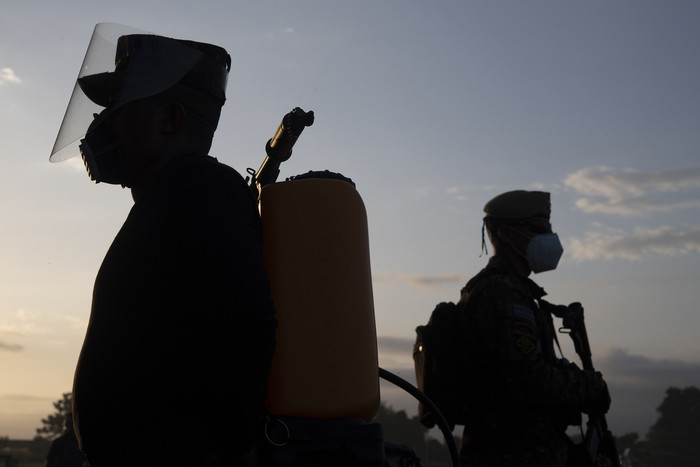 Soldados salvadoreños cargan equipos para combatir la plaga de Langostas en la zona de San Vicente, el 18 de julio. 




 · Foto: Yuri Cortez / AFP