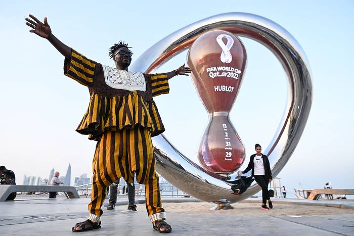 Un hincha de la selección nacional de fútbol de Ghana posa con el reloj de cuenta regresiva de la Copa Mundial de la FIFA en Doha el 7 de noviembre de 2022. · Foto: Kirill Kudryavstsev, AFP
