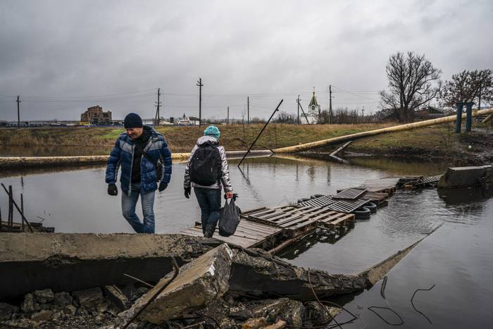 Residentes de Bakhmut, región de Donetsk, en un puente improvisado. · Foto: Dimitar Dilkoff, AFP