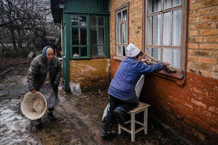 Habitantes de Chasiv Yar, próximo a Bajmut reparan aberturas rotas tras un bombardeo ruso, el 28 de febrero. · Foto: Dimitar Dilkoff, AFP