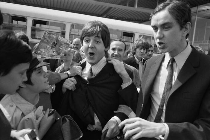 Paul McCartney (C) y George Harrison (D), a su llegada al aeropuerto de Orly, en París, antes de su concierto en el Palais des Sports (archivo, junio de 1965). · Foto: AFP
