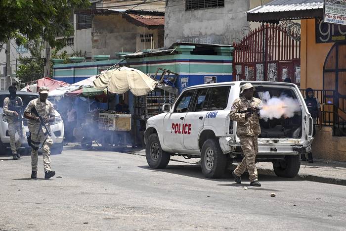 Agentes de policía lanzan gases lacrimógenos a manifestantes durante una protesta contra la inseguridad en Carrefour-Feuilles, un distrito de Puerto Príncipe, Haití, el 14 de agosto. · Foto: Richard Pierrin, AFP