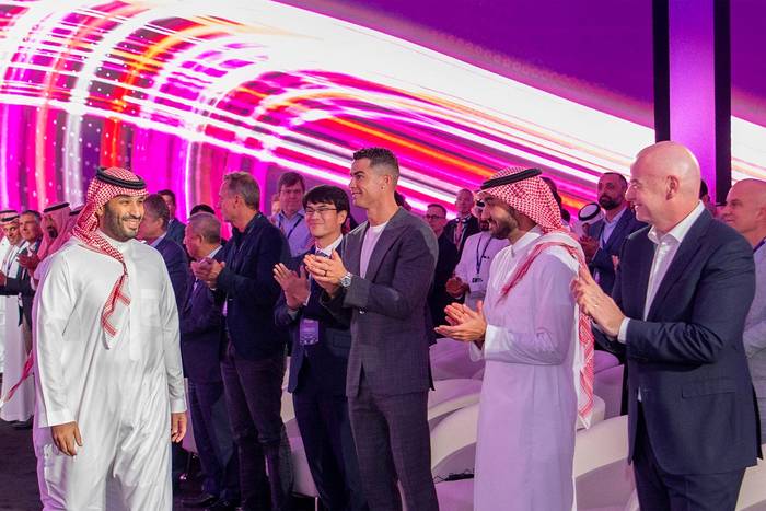 Mohammed bin Salman es recibido por Gianni Infantino y Cristiano Ronaldo, durante el lanzamiento de la Copa del Mundo de Esports en Riad, el 23 de octubre en Arabia Saudita. Foto: SPA, AFP