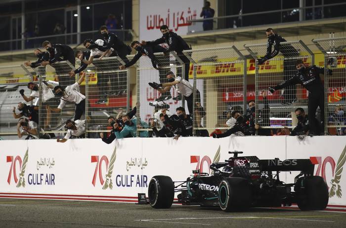 El piloto británico de Mercedes, Lewis Hamilton, recibe el saludo de su equipo de boxes tras ganar el Gran Premio de Fórmula Uno de Bahréin en el Circuito Internacional de Bahréin en la ciudad de Sakhir, el 29 de noviembre de 2020. · Foto: Brynn Lennon, pool, AFP