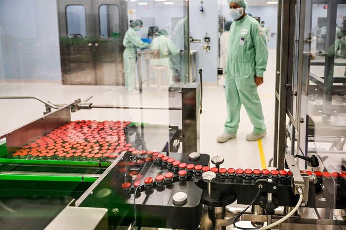 Un técnico de laboratorio supervisa viales tapados durante las pruebas de llenado y envasado para la producción y suministro a gran escala de la vacuna candidata COVID-19 de la Universidad de Oxford. · Foto: Vincenzo Pinto, AFP