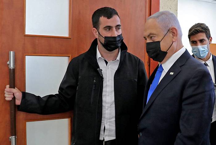 El primer ministro israelí, Benjamin Netanyahu, abandona la sala del tribunal de distrito en Jerusalén el 5 de abril de 2021, durante su juicio por corrupción. · Foto: Abir Sultan / Pool / AFP