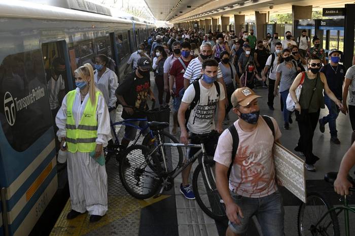 Una trabajadora espera para desinfectar la cabina de un tren de cercanías mientras los pasajeros descienden en la estación de tren de Once en Buenos Aires, el 7 de abril de 2021, en medio de la nueva pandemia de coronavirus. · Foto: Juan Mabromata, AFP