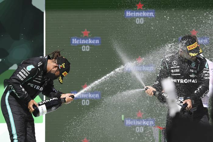 Lewis Hamilton, ganador, y su compañero del equipo Mercedes, Valtteri Bottas (tercero), en el podio del Gran Premio de Portugal de Fórmula Uno, en el circuito de Portimao. 


 · Foto: Patricia De Melo Moreira / AFP