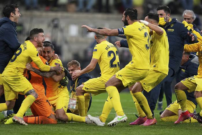 Los jugadores de Villarreal, y el arquero Gerónimo Rulli, tras la atajada del penal que les dió la victoria en la final de la Europa League ante Manchester United, en el estadio de Gdansk, en Polonia.




 · Foto: Michael Sohn, pool, AFP