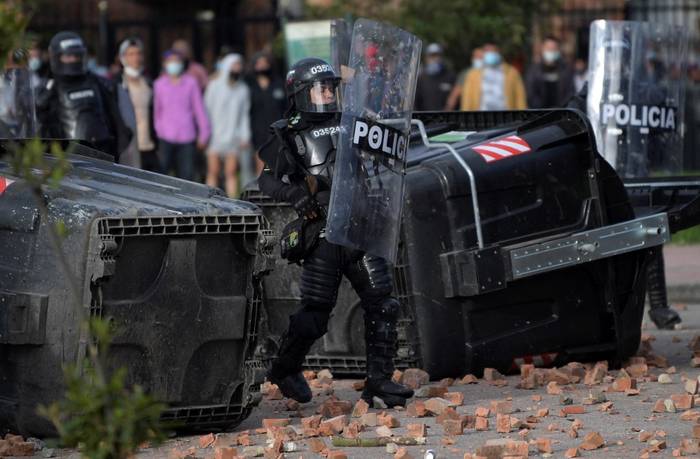 Un policía antidisturbios se enfrenta a los manifestantes que protestan contra el gobierno del presidente colombiano Iván Duque en el barrio de Suba, Bogotá, el 29 de junio de 2021. · Foto: Raúl Arboleda, AFP