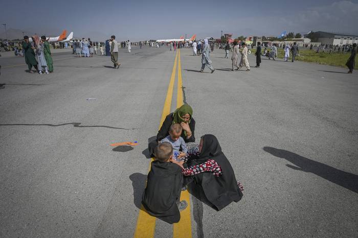 Ciudadanos afganos en una pista del aeropuerto de Kabul, a la espera de poder abandonar el país, tras el regreso al poder del Movimiento Talibán. · Foto: Wakil Kohsar, AFP