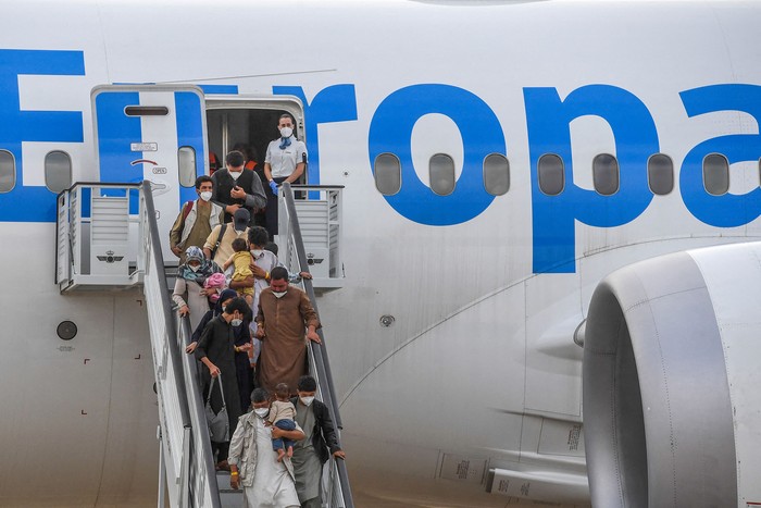 Refugiados desembarcan de un vuelo de evacuación de Kabul, este martes, en la base aérea de Torrejón de Ardoz. · Foto: Pierre Philippe Marcou, AFP
