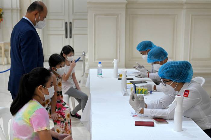 Los nietos del primer ministro de Camboya, Hun Sen, esperan recibir dosis de la vacuna contra el coronavirus, en el Palacio de la Paz, en Phnom Penh. · Foto: AFP