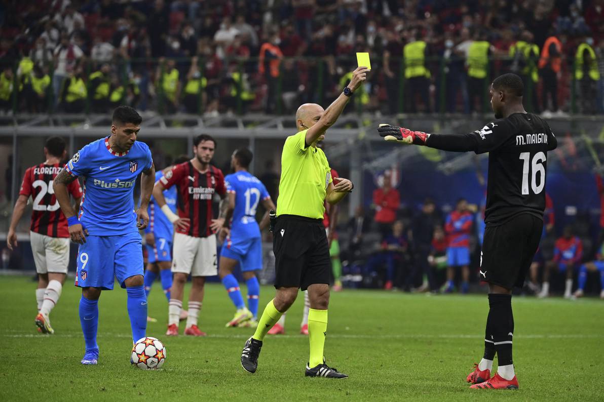 Luis Suárez, el árbitro Cuneyt Cakir, y el arquero Mike Maignan, de Milan, previo al penal que le dio la victoria a Atlético Madrid, en Milan.