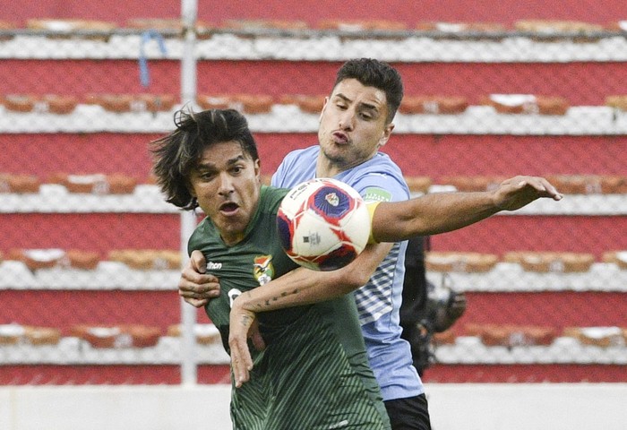 Marcelo Martins, de Bolivia, y José María Giménez, de Uruguay, durante el partido por las eliminatorias, el 16 de noviembre, en La Paz. · Foto: Aizar Raldes, AFP