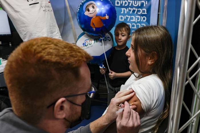 Vacunación con Pfizer para Covid-19 a un niño de nueve años, en los Servicios de Salud Clalit, el 23 de noviembre, en Jerusalén. · Foto: Menahen Kahana, AFP