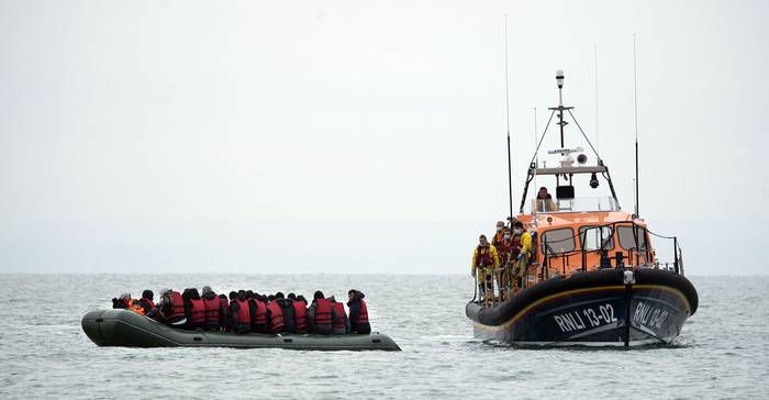 Los migrantes son ayudados por el bote salvavidas RNLI (Royal National Lifeboat Institution) antes de ser llevados a una playa en Dungeness, en la costa sureste de Inglaterra, el 24 de noviembre de 2021, después de cruzar el Canal de la Mancha. · Foto: Ben Stansall, AFP