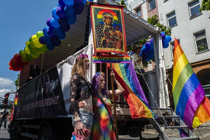 Participantes de la Marcha del Orgullo Gay, con una pancarta de la Iglesia Gay de Berlín. (archivo, junio de 2021) · Foto: John Macdougall, AFP