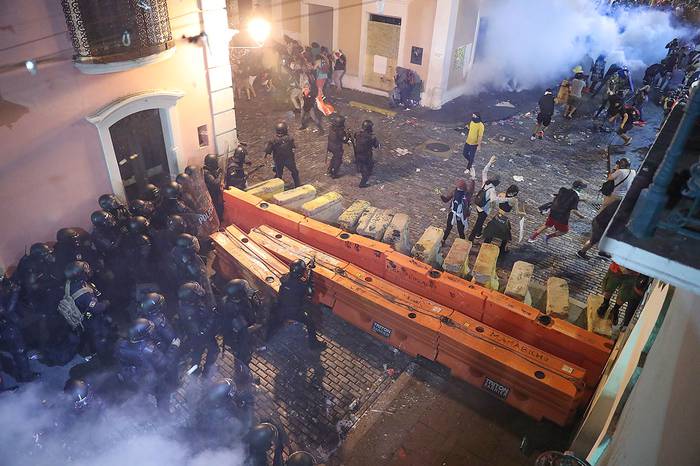 Enfrentamiento entre la Policía y manifestantes en una calle que conduce a la casa del gobernador Ricardo Rosselló.
 · Foto: Joe Raedle, AFP