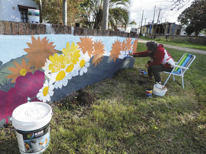 Ester Arén pinta el muro de su casa. · Foto: Emilio Martínez Muracciole
