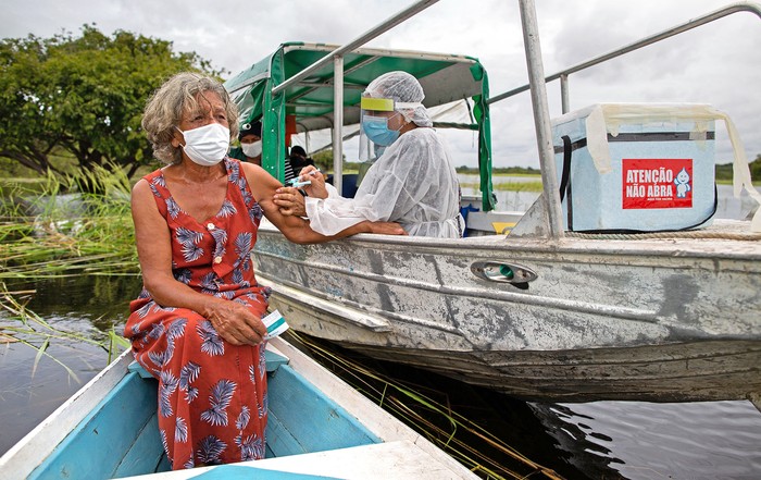 Olga D'arc Pimentel, de 72 años, recibe la vacuna Oxford-AstraZeneca, el 9 de febrero, en la comunidad de Nossa Senhora Livramento, estado de Amazonas, Brasil.
 · Foto: Michael Dantas, AFP