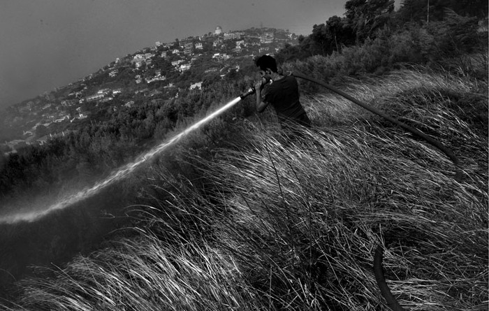 Un voluntario combate las llamas en la población griega de Pedeli, 20 kilómetros al norte de Atenas, Grecia · Foto: EFE, Kostas Tsironis