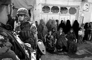 Mujeres esperan ante soldados italianos de la OTAN a que dé comienzo la inauguración de una escuela, el lunes, en Herat, Afganistán.