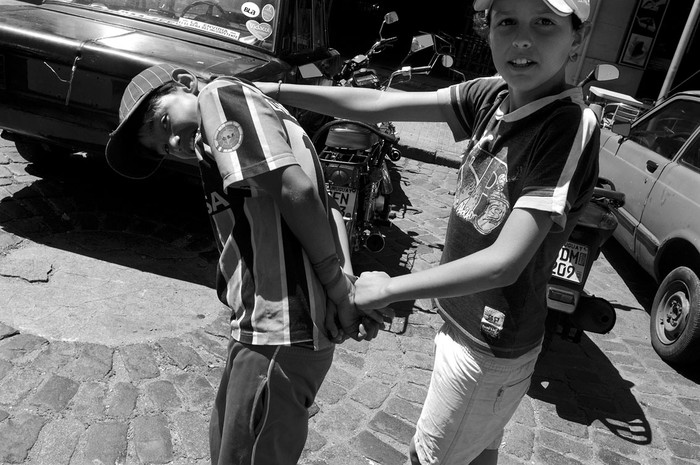 Dos niños juegan a que uno lleva detenido al otro. Rambla, cerca del Mercado del Puerto. / archivo, enero 2010.
 · Foto: Ricardo Antúnez