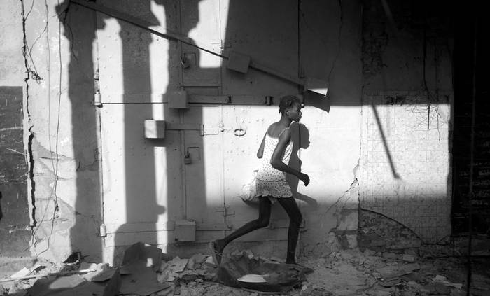 Una mujer corriendo, ayer, con mercancía robada tras el saqueo a un negocio del centro de Puerto Príncipe (Haití). 
 · Foto: Efe, Shawn Thew