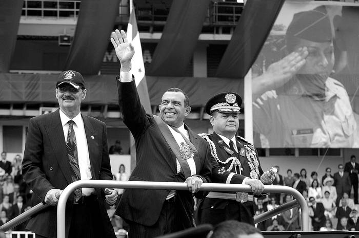 El presidente hondureño, Porfirio Lobo, saluda junto al ministro de Defensa, Adolfo Lionel Sevilla, y al general Romeo Vásquez Velásquez, durante su ceremonia de posesión en el Estadio Nacional de Tegucigalpa.  · Foto: EFE, Gustavo Amador