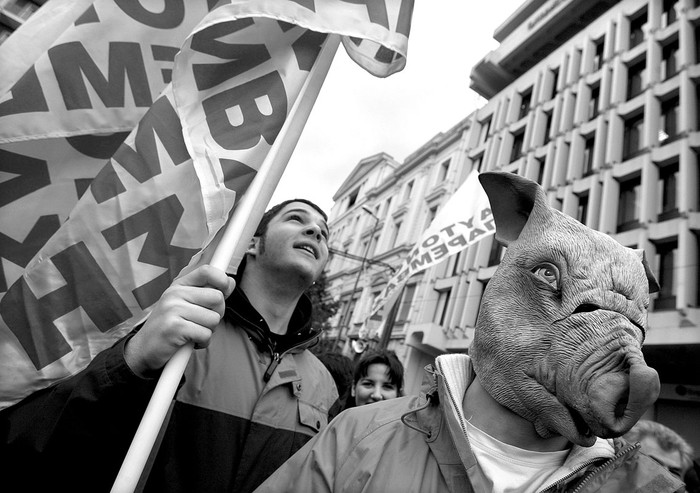 Uno de los asistentes a la huelga convocada por los funcionarios públicos viste una máscara de cerdo durante una marcha en el centro de Atenas, Grecia, el miércoles 10. Los manifestantes han protestado contra el aumento de los impuestos y el congelamiento de los salarios impuesto por el gobierno.  · Foto: Efe, Simela Pantzartzi