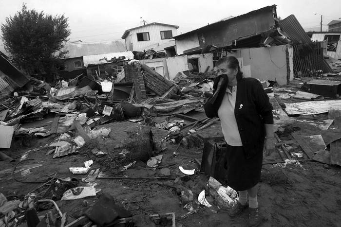  Una mujer llora ayer, entre los escombros de las viviendas destruidas en la localidad de Penco, a 475 kilómetros al sur de Santiago (Chile). · Foto: Efe, Claudio Reyes