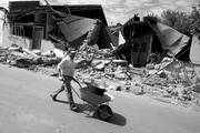 Un hombre transporta una olla en una carretilla, cerca a restos de viviendas en Concepción, destruidas tras el terremoto de 8,8 grados en la escala de Richter que sacudió el pasado sábado el centro y sur del país. 