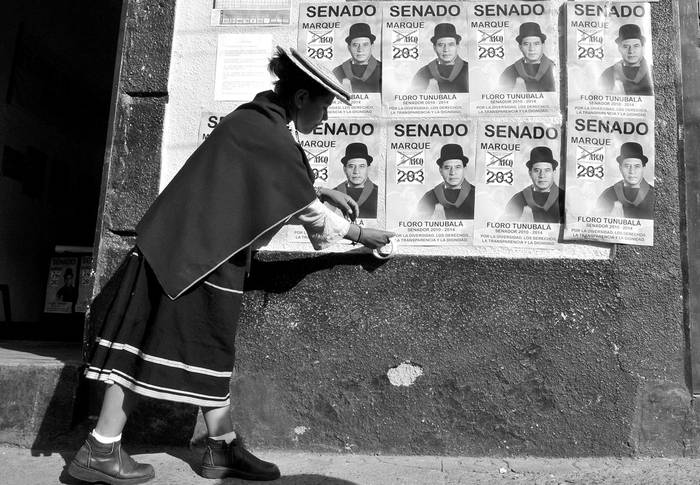 Una indígena guambiana pega publicidad política en el municipio de Silva, departamento del Cauca.  · Foto: Efe, Carlos Ortega