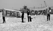 Cuatro israelíes portan una pancarta de apoyo a la Franja de Gaza en el puerto de Ashdod (Israel)