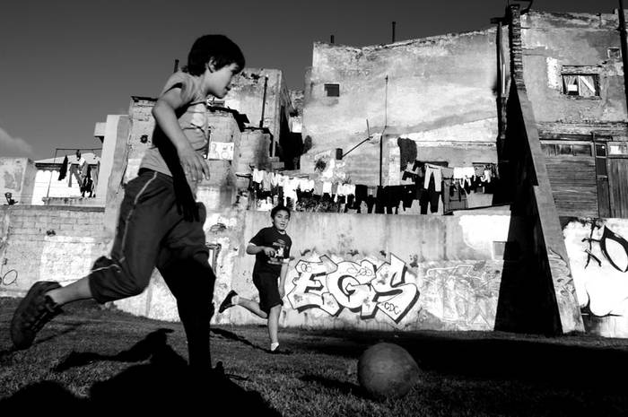  Niños jugando al fútbol al costado del arroyo Miguelete, en la zona de Paso Molino. Montevideo, 2010.
 · Foto: Ricardo Antúnez