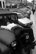 Un cuidacoches duerme sobre el capot de un auto en la calle Reconquista. Montevideo, 2010.