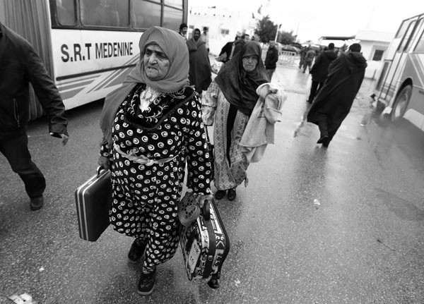 Tunecinos residentes en Libia atraviesan el puesto fonterizo de Ras Jdir para escapar de la situación que vive el país tras la represión violenta de las manifestaciones contra el régimen de Muamar el Gadafi, en Ras Jdir, Túnez.
 · Foto: Efe, Mohamed Messara