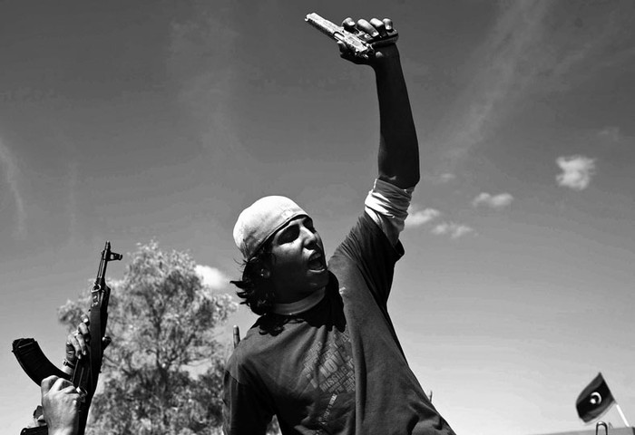 Mohamed el Bibi, de 20 anos de edad, muestra la pistola chapada en oro que supuestamente pertenecia a Gadafi y que obtuvo al descubrir al lider libio refugiado en un agujero cerca de la ciudad de Sirte.
 · Foto: Efe, Guillem Valle