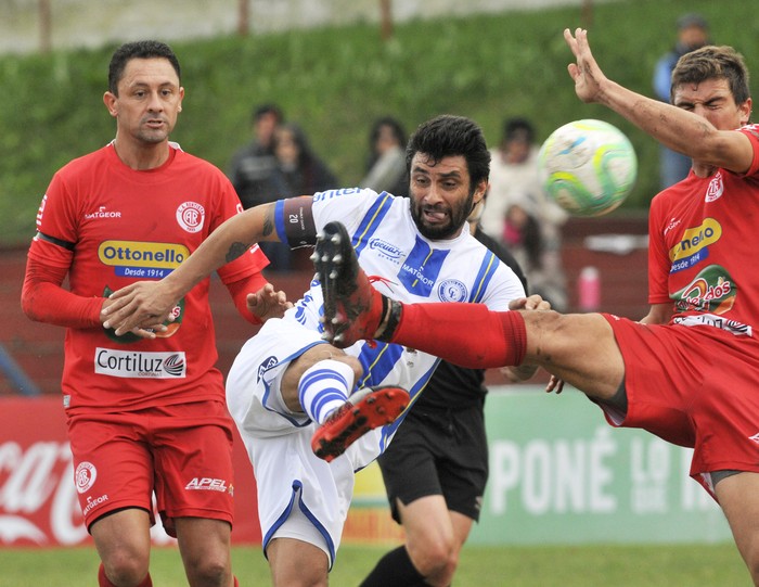 Rodrigo Vázquez, de Rentistas, Carlos Bueno, de Cerro Largo, y Andrés Curbelo, de Rentistas, durante el partido jugado en el Parque Palermo. Foto: Federico Gutiérrez · Foto: Federico Gutiérrez