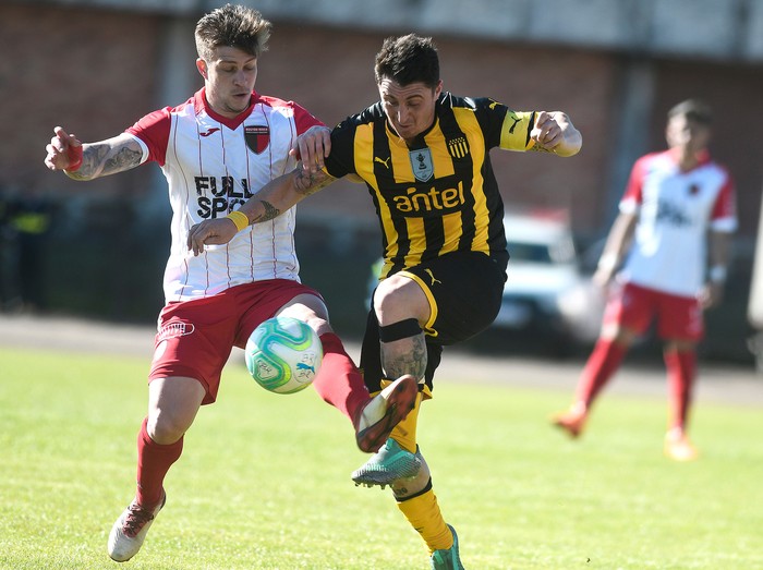 Federico Gallego, de Boston River, y Cristian Rodríguez, de Peñarol, en el estadio Atilio Paiva Olivera de Rivera. /adhocFotos · Foto: Javier Calvelo