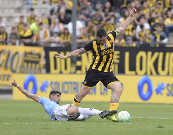 Darío Pereira, de Torque, y Cristian Rodríguez, de Peñarol, en el estadio Campeón del Siglo. · Foto: Sandro Pereyra